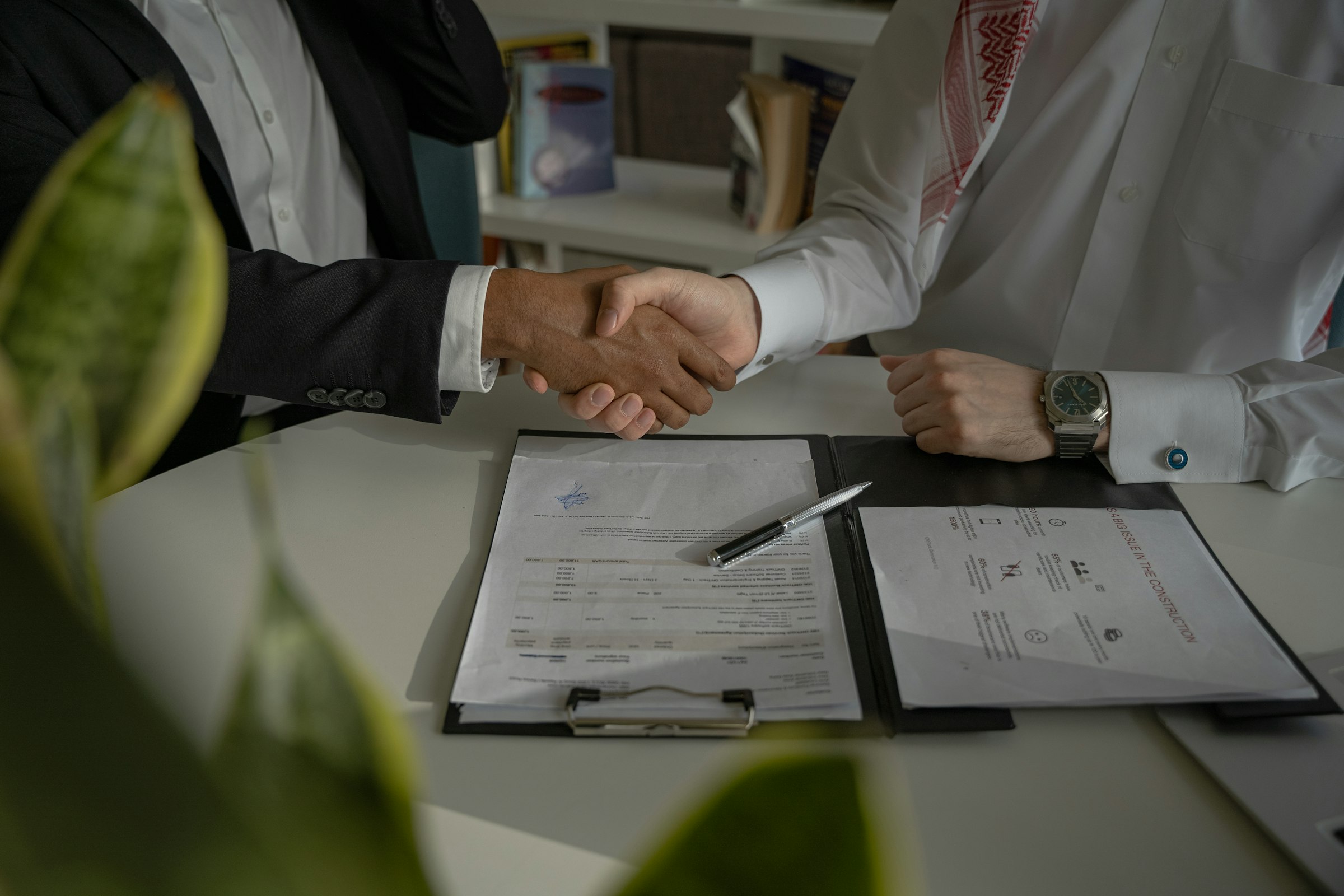 Broker and client shaking hands over a signed policy document