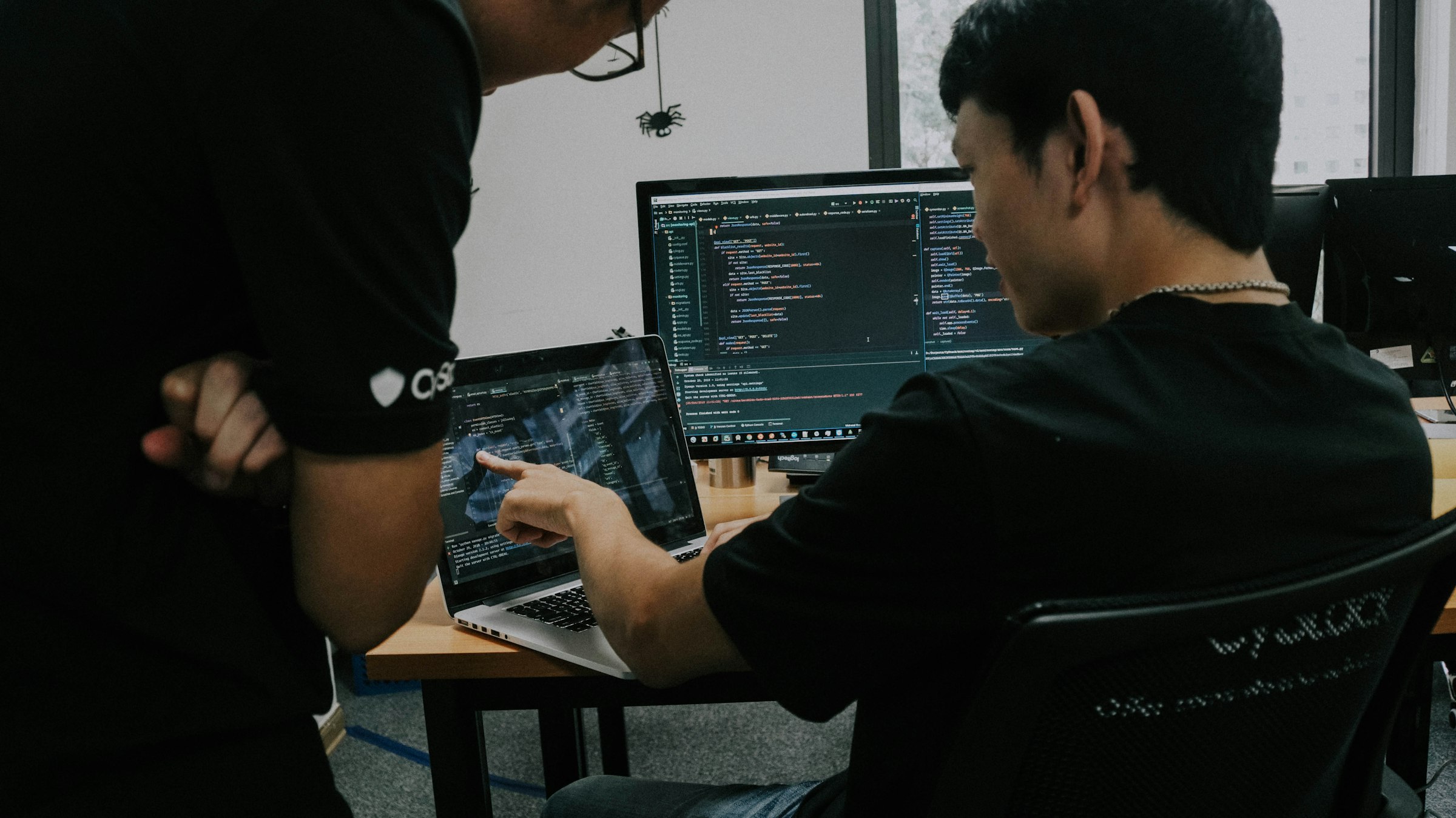 Two developers working together at their screens in an office