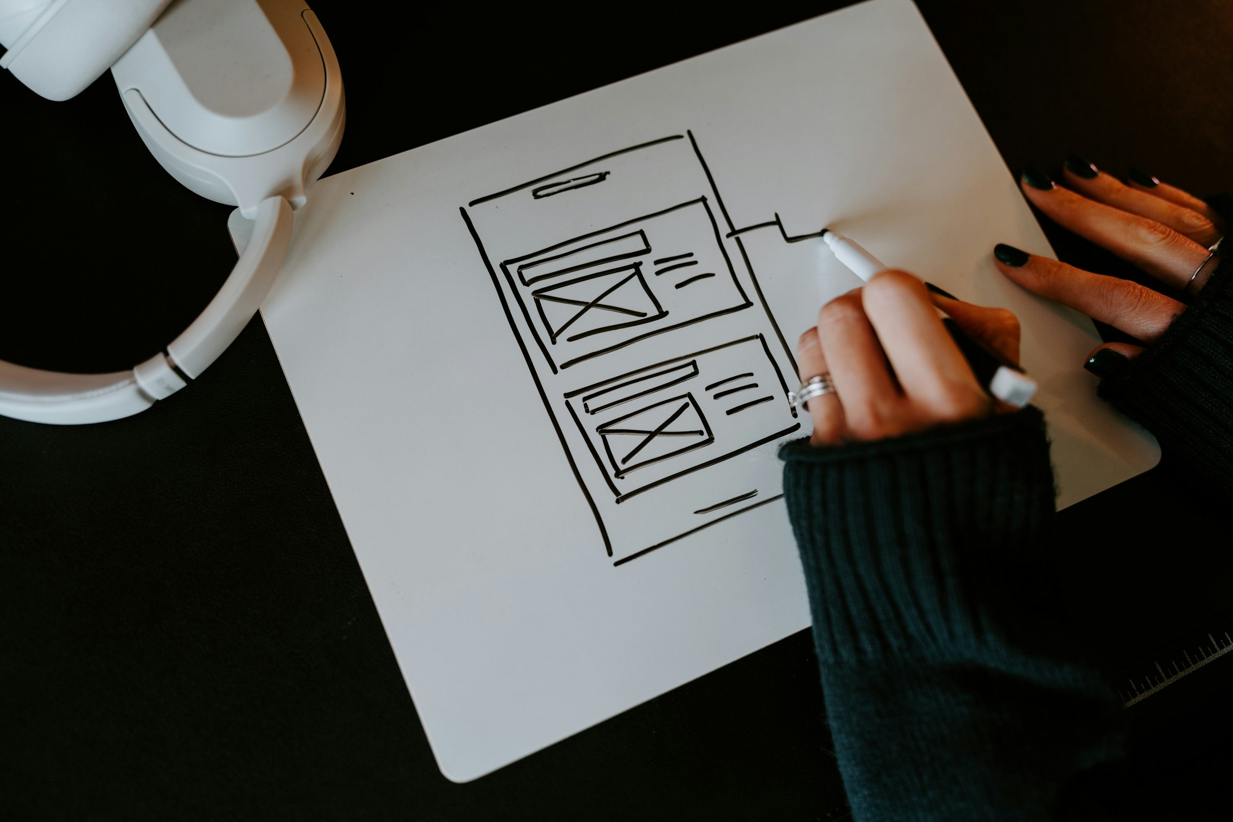 Hand sketching an app wireframe on paper
